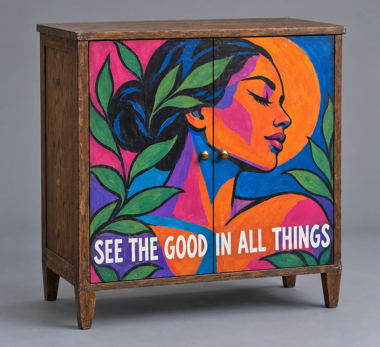 Concept render of a secondhand wooden cabinet, its doors painted with a bold mural of a woman's profile in orange, magenta and blue, with the words See the good in all things